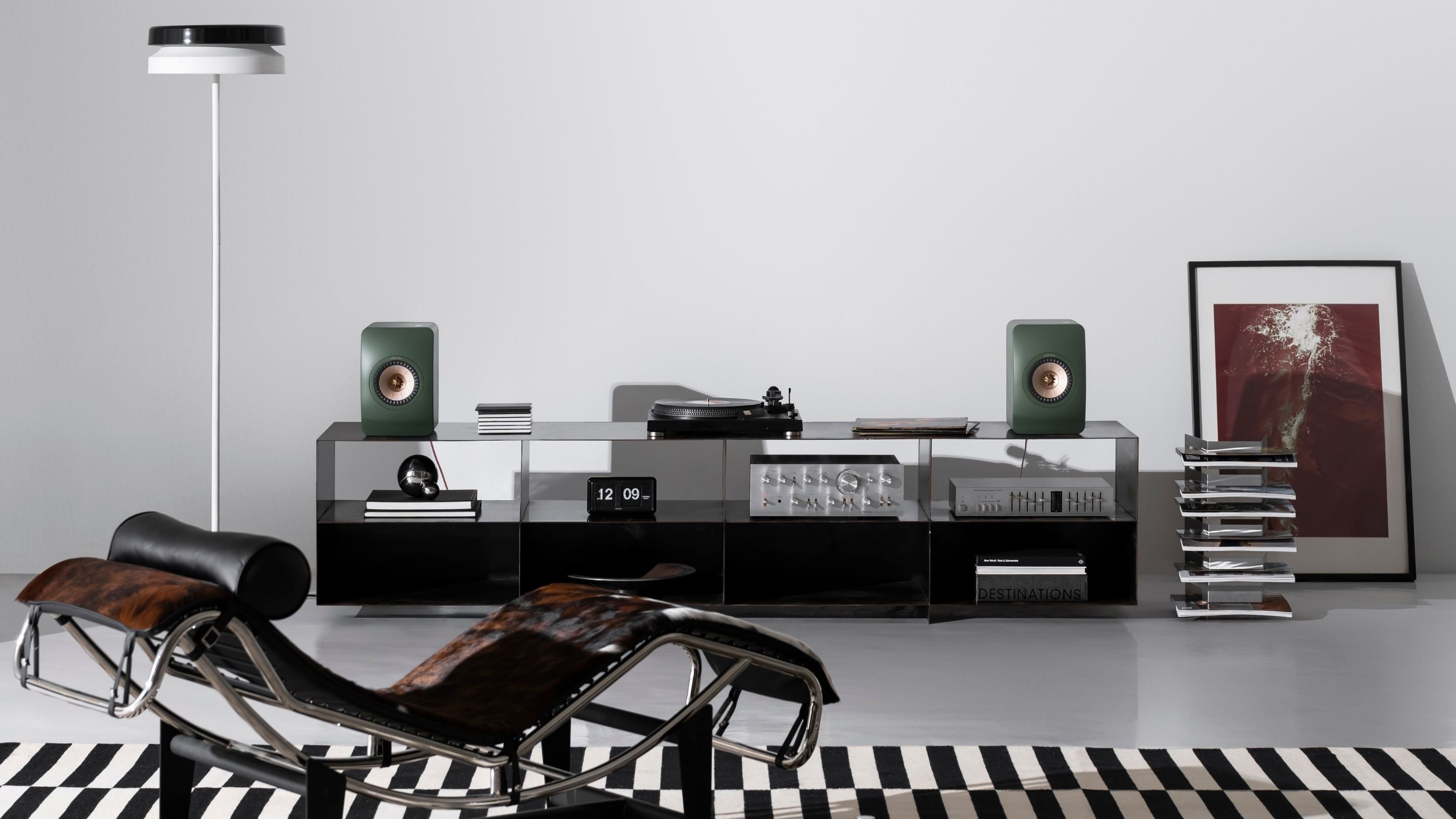 Modern living room with a turntable setup, chair,  framed picture & LS50 Meta speakers