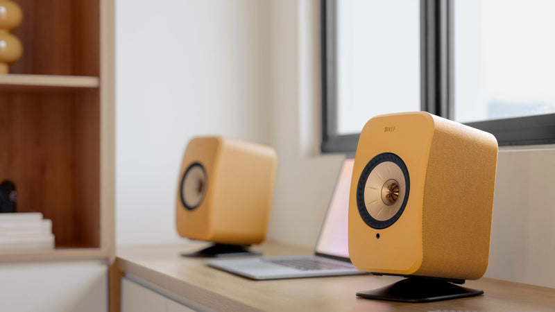 Close up of a yellow LSX II HiFi Bluetooth speaker placed on a P1 Desk pad 